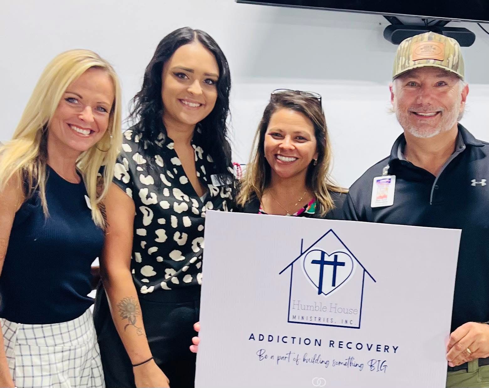 A-Team Members holding up sign of Humble House Ministries for Addiction Recovery.
